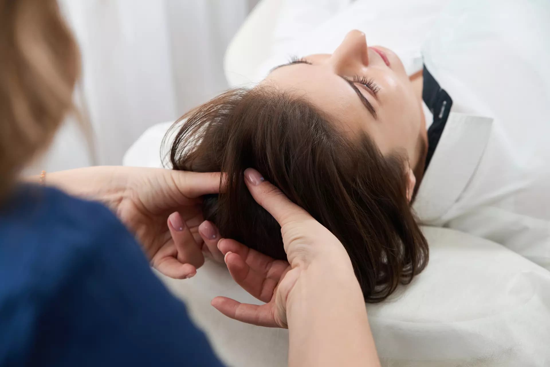 Hands of a chiropractor performing a gentle head adjustment